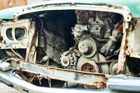 Details of old car. Aged oldtimer vintage automobile. Spare parts of retro classic automobile. Disassembled car in a parking lot.の写真素材