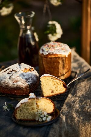 Traditional russian Easter cottage cheese dessert. Orthodox paskha, kulich cakes on table. Flowers bokeh background.の写真素材