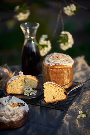 Traditional russian Easter cottage cheese dessert. Orthodox paskha, kulich cakes on table. Flowers bokeh background.の写真素材