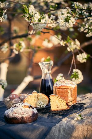 Traditional russian Easter cottage cheese dessert. Orthodox paskha, kulich cakes on table. Flowers bokeh background.の写真素材