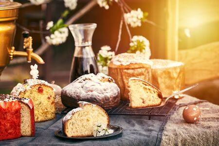 Traditional russian Easter cottage cheese dessert. Orthodox paskha, kulich cakes on table. Flowers bokeh background.の写真素材