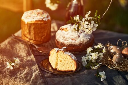 Traditional russian Easter cottage cheese dessert. Orthodox paskha, kulich cakes on table. Flowers bokeh background.の写真素材