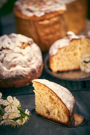 Traditional russian Easter cottage cheese dessert. Orthodox paskha, kulich cakes on table. Flowers...