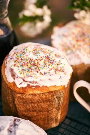 Traditional russian Easter cottage cheese dessert. Orthodox paskha, kulich cakes on table. Flowers...