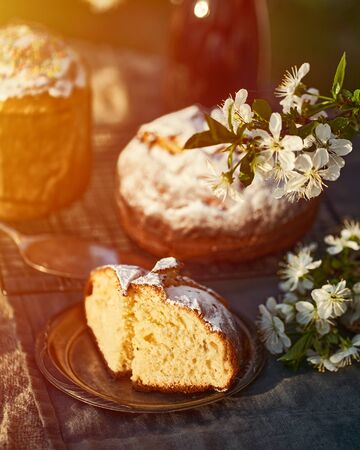 Traditional russian Easter cottage cheese dessert. Orthodox paskha, kulich cakes on table. Flowers bokeh background.の写真素材