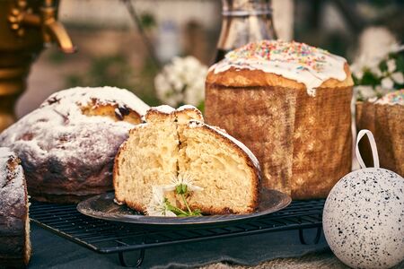 Traditional russian Easter cottage cheese dessert. Orthodox paskha, kulich cakes on table. Flowers bokeh background.の写真素材