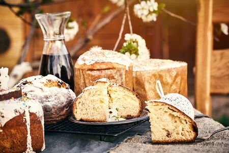 Traditional russian Easter cottage cheese dessert. Orthodox paskha, kulich cakes on table. Flowers bokeh background.の写真素材