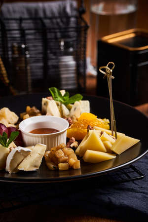 Cheese plate with grapes and nuts on wooden table. Close up viewの写真素材