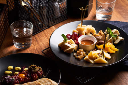 Cheese plate with grapes and honey on wooden table.の写真素材