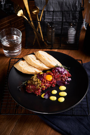Tartare from beef with egg and bread in restaurant.の写真素材