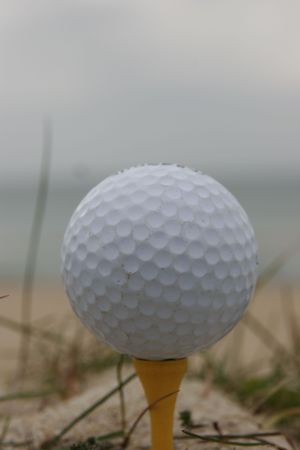 a golf ball with a beach behindの写真素材