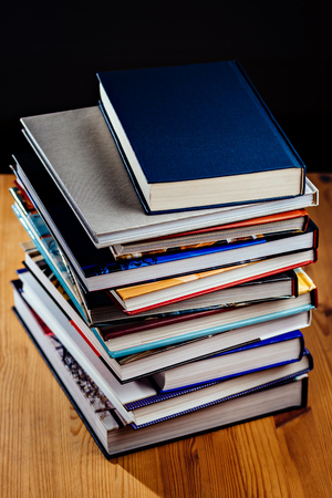 Pile of books on a wooden desk