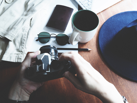 Work space with shirt, a hat and hand holding a cameraの写真素材