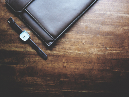 there are watch, laptop and leather bag on wooden table, minimal style,  soft toneの写真素材