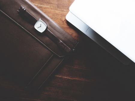 there are watch, leather bag and laptop on wooden table, minimal style,  soft toneの写真素材