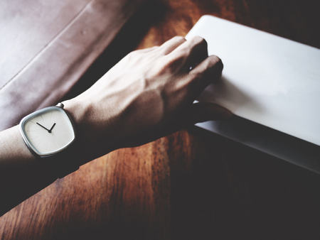 there are watch, laptop and leather bag on wooden table, minimal style,  soft toneの写真素材