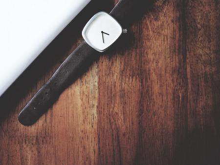 there are watch, laptop and leather bag on wooden table, minimal style,  soft toneの写真素材