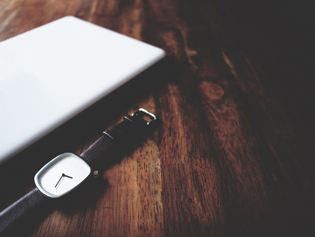 there are watch, laptop and leather bag on wooden table, minimal style,  soft toneの写真素材