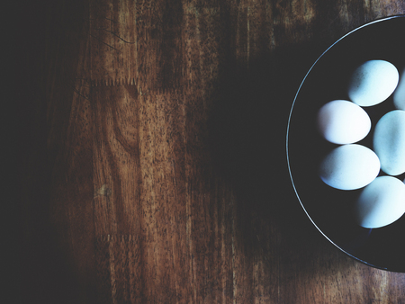 This is duck egg in the black plate above wooden desk,  soft toneの写真素材