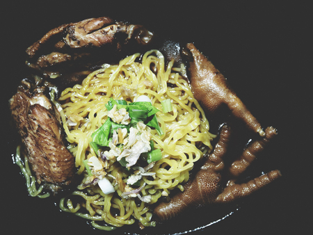 This is egg noodles with chicken soup in the black plate,  soft toneの写真素材