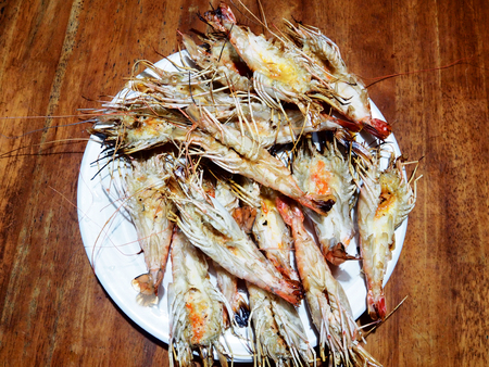 This is grilled prawns in white plate above  woodenの写真素材