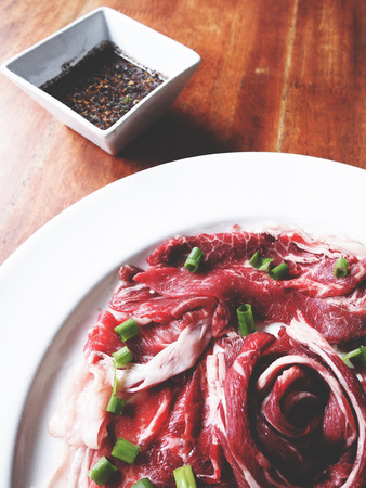 This is Australia raw beef in white plate and northeast Thai style sauce, soft  toneの写真素材