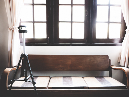 There are tripod, wooden sofa, leather seat in the picture, indoor at home,  soft toneの写真素材