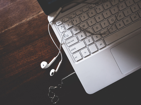 This is white headphone and white laptop on wooden table,  soft toneの写真素材