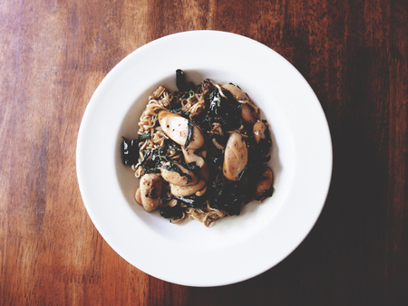 This is Fried noodles and sausage with garlic and dried chili on white plate, soft toneの写真素材