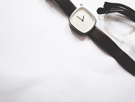 The picture of glasses and watch on white paper, soft tone color,  copy space