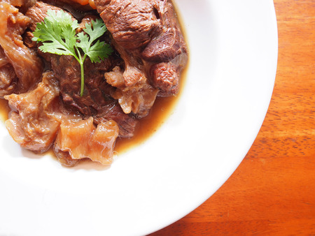This is a meat lover's paradise. The picture of beef stew in Chinese style on white plate above  wooden table.の写真素材