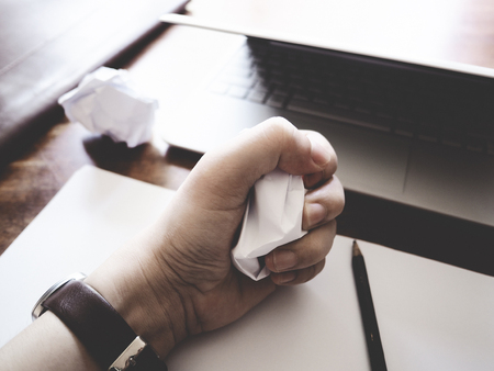 Businesses have both been successful and fail. The picture of paper, pencil, laptop, and hand gesture above wooden table.  selective focusの写真素材
