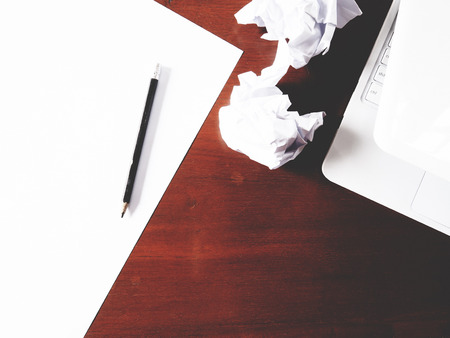 Businesses have both been successful and fail. The picture of paper, pencil, laptop, and men hand gesture above wooden table.  soft toneの写真素材