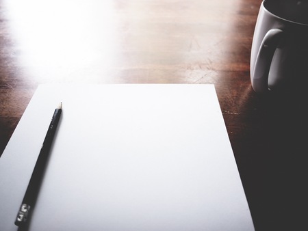 Why not do you turn ideas into money? The picture of paper, pencil, laptop, coffee cup and men hand gesture above wooden table. selective focus,  soft toneの写真素材