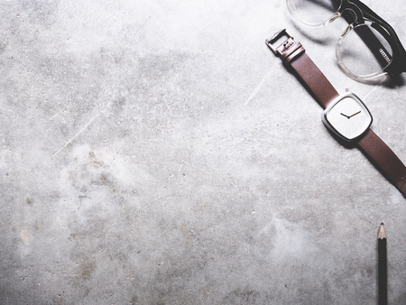 This is office equipment in minimal style, The picture of pencil, glasses and watch on cement...