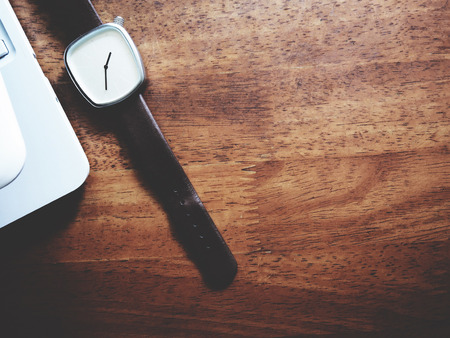 Top view picture of white laptop and watch in minimal style above old wooden background.  soft tone colorの写真素材