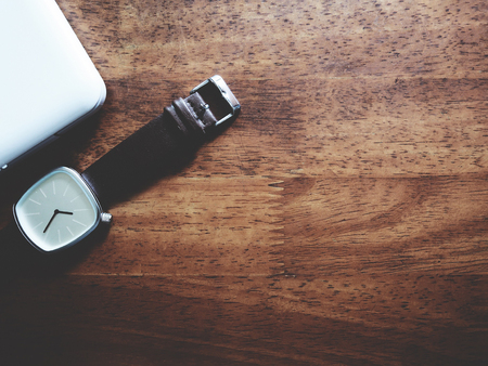 Top view picture of white laptop and watch in minimal style above old wooden background.  soft tone colorの写真素材
