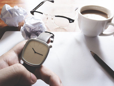 Businesses have both been successful and fail. The picture of fail work, glasses, paper, pencil, watch, a cup of coffee  and men hand gesture above wooden table.selective focus.  soft tone colorの写真素材