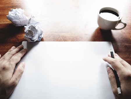 Businesses have both been successful and fail. The picture of fail work, paper, pencil, a cup of coffee  and men hand gesture above old wooden table.の写真素材