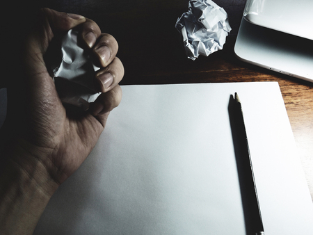 This is the failed work action on wooden table at night, consist of laptop, paper, and pencil. low  light styleの写真素材