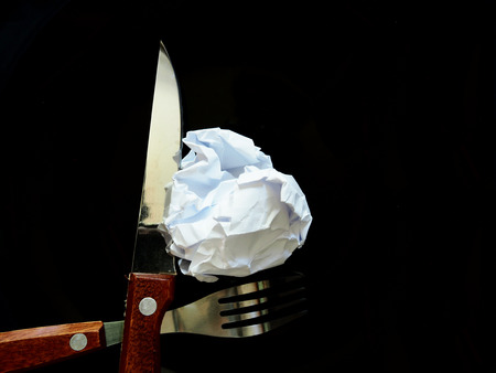 No work No money and No food. The picture of failed work condition consist of disastrously paper on white dish, pencil, fork, spoon, hand and knife above wooden table. selective focus. soft tone styleの写真素材