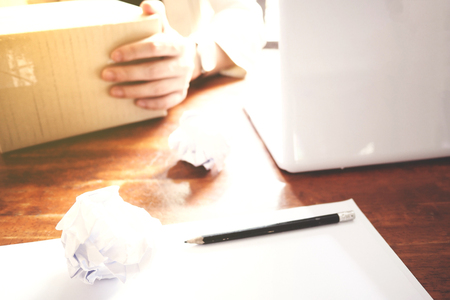 The picture of Asian Businessmen are saddened by the failure of his work on wooden table at office, consist of white laptop, paper, and hands. selective focusの写真素材