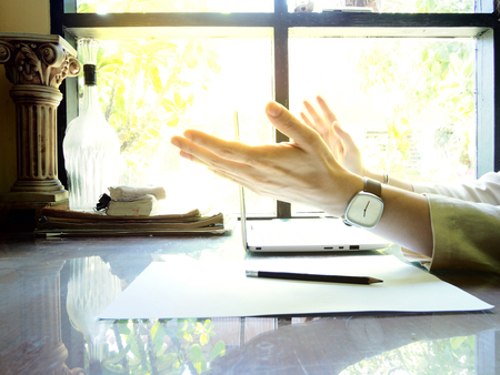 Businesses happen everywhere, just have inspiration. The picture of white laptop with Male hand on wooden table near the window at home office. selective focusの写真素材