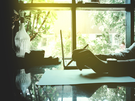 Businesses happen everywhere, just have inspiration. The picture of white laptop with Male hand on wooden table near the window at home office. selective focusの写真素材