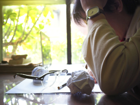 Businesses happen everywhere, just have inspiration. The picture of businessman are tired with his work on wooden table near the window at home office. selective focusの写真素材