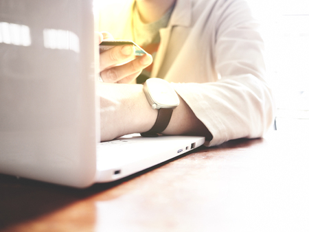 A man wear a white suit is proceeding an online Financial Transactions with credit card and white laptop. Online Financial Transactions concept. selective focusの写真素材
