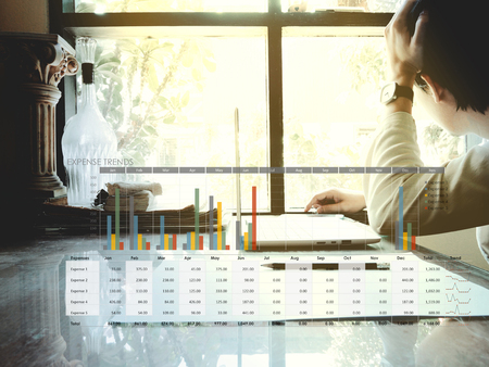 The picture of expense trends graph on workspace background. Financial management conceptの写真素材