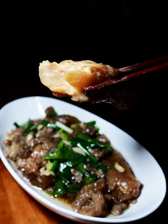 The picture of stir fried beef stew with green peppers on white dish, black background. selective focusの写真素材