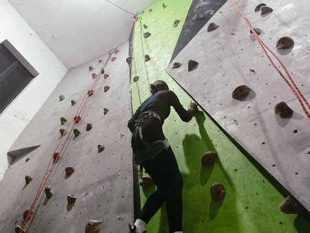 Young Woman climbing on a wall in an indoor climbing gym, extreme sportの写真素材