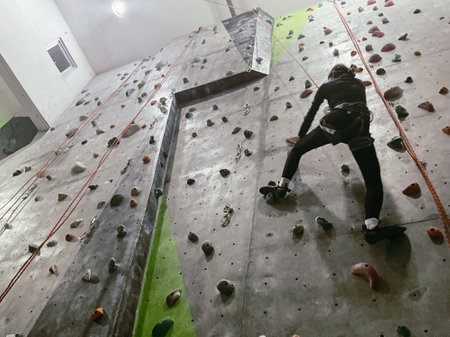 Young Woman climbing on a wall in an indoor climbing gym, extreme sportの写真素材